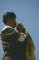 Tibetan man blowing conch shell at festival