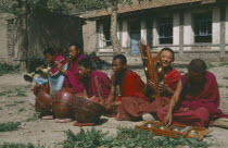 Buddhist monks orchestra playing in courtyard of Labrabg monastery