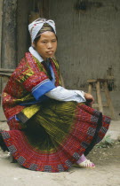 Seated Miao girl in festival dress