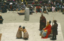 Clowns performing at a Full Moon Festival with onlookers.