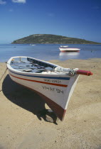 Fishing boat on beach with Ile Morne behind