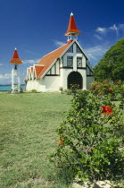 Red and white chapel with garden in front