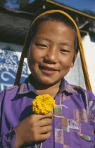 Smiling boy holding yellow flower