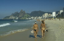 Girls walking along Ipanema beach.