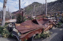 Mount St Helens National Volcanic Monument. Crushed car and flattened bare trees in the aftermath of the 1980 eruption