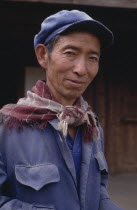 Portrait of a Naxi man wearing a cap and scarf