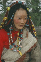 Tibetan woman in traditional clothes wearing beads in hair and around neck