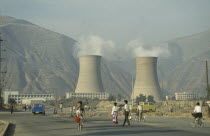 Coal Power Station with people walking in the foreground.