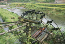 Bamboo water wheel on the edge of a river.