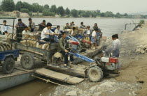 Men taking a tractor off a ferry