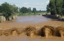 View up the muddy irrigation canal.