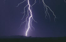 Fork lightning in electric storm at night striking ground