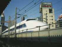 Shinkansen Bullet Train speeding along raised railway line in the centre of Tokyo