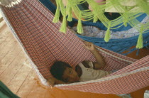 Young boy lying in a hammock on a boat