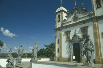 O Santuario de Bom Jesus de Matosinhos with some of the twelve statues of prophets sculpted by Aleijadinho standing outside