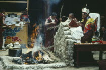 Chief Lama seated saying prayers over a fire at a festival