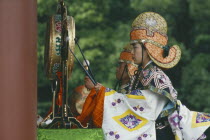 Man in costume beating gong at festival