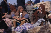 Women sitting with bundles of clothing at the Sunday Market
