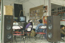 Youths watching television in shop.