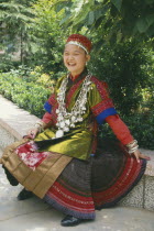 Seated Miao girl  wearing festival dress