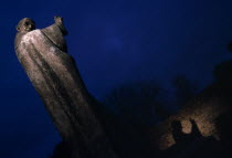 Statue of Saint Richard partially illuminated at night in Cathedral grounds with shadow reflecting on nearby wall.European Great Britain Nite Northern Europe UK United Kingdom British Isles History