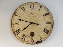 A classic clock face with Roman numerals against a plain background.  Time