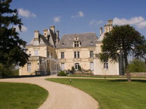 Gravelled path leading up to the iron entrance gate of the Chateau des Forges.