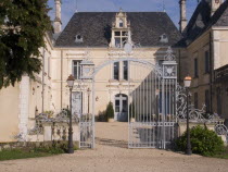 Iron entrance gate and lampposts in front of the Chateau des Forges.