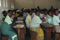 Mozambican refugee women attending adult literacy class. Young woman in foreground with child asleep on her back.