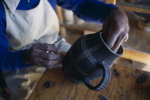 Dedza Potteries producing Fair Trade goods for export.  Craftsman decorating pot.