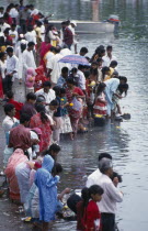 Crowds making offerings of flowers and fruit in the Grand Bassin lake during the Maha Shivaratree festival in honour of the Hindu god Siva.