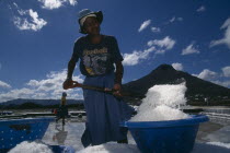 Female workers filling salt pans to earn eighty-four ruppees a day.