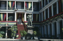 Exterior of Government House hung with flags and banners in celebration of Republic Day with statue of William Stevenson governor 1857-1863 in foreground.