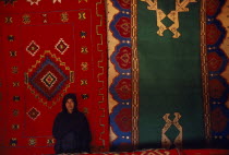 Sahrawi woman standing in front of traditional carpets.SADR Sahrawi Arab Democratic Republic Morocco disputed area