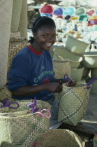 Girl making rafia baskets on market stall.Tana  craft