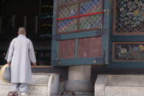 Jogyesa Temple. A Nun walking up the steps to the temple sanctuary