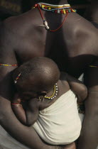Cropped shot of Bassari mother carrying child on her back.