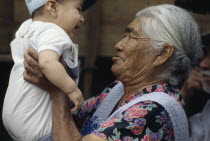 Proud grandmother holding up grandson.