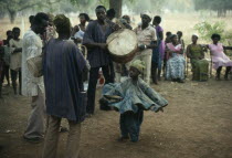Small child dancing to drumming musicians at wedding.