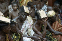 Ashanti elders wearing traditional headdresses decorated with gold at tribal meeting. Asante