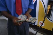 Ghanaian currency.  Counting cedi bank notes at a petrol station.Gasoline