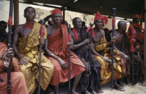 Ashanti Akan tribal members holding staffs wrapped with red cloth attending funeral.  Red is the colour of mourning.  Asante Color