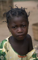 Portrait of young girl from small village near Accra with her hair twisted into multiple short braids.