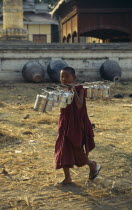 Young Monk carrying Tiffin Boxes over his shoulder Burma
