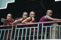 Monks leaning on balcony at Ywama Monastry Burma
