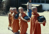 Novice monks carrying Alms bowlsBurma Myanmar Yangon