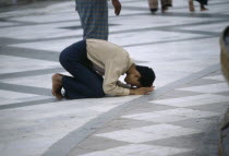 Man praying on floor at Shwedagon PagodaBurma Rangoon Shwe Dagon