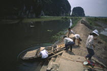 People transferring boat over lock