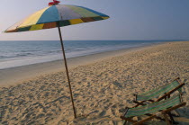 Khao Lak  A multi coloured parasol and two deck chairs on the sandy beach.Colored umbrella