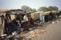 People selling fruit and vegetables and other food stuffs from under market shelters